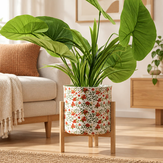 Green potted plant in a decorative pot on a stand against a white background