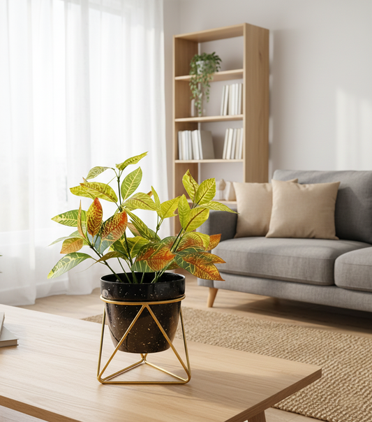 Living room with a potted plant on a wooden table, gray sofa, and bookshelf.