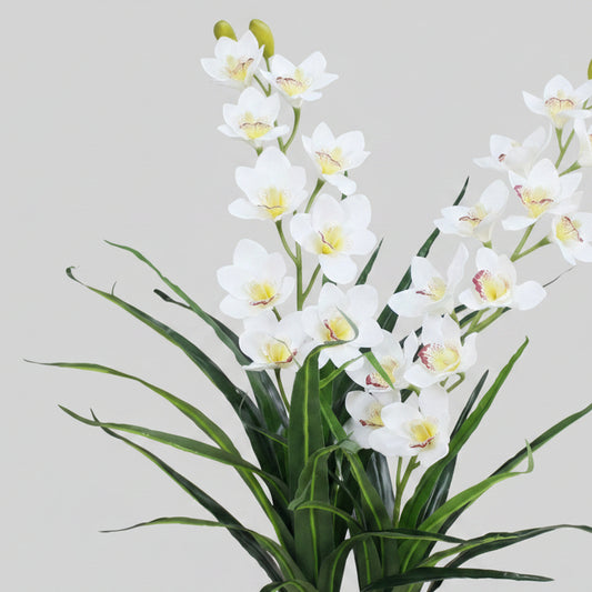 Artificial white orchids with green stems on a light gray background