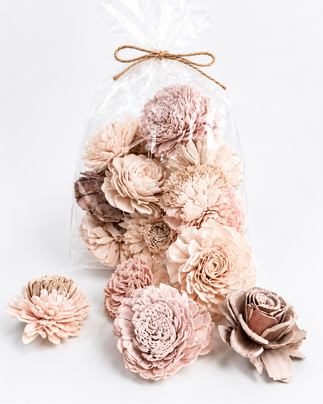 Decorative wall art with pink and beige flowers in a clear bag on a white background
