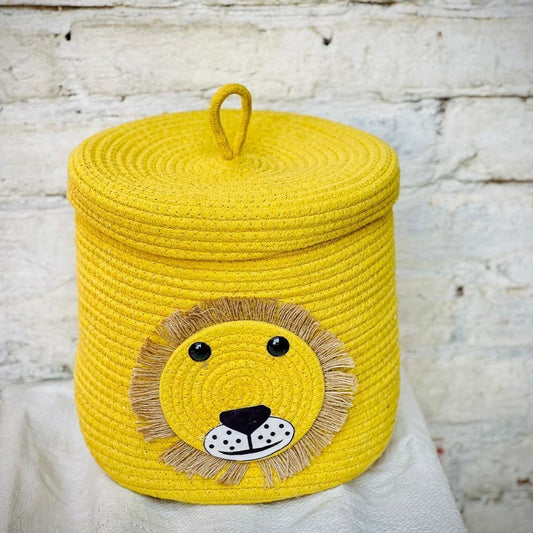 Yellow woven storage basket with a lion face design on a white surface.