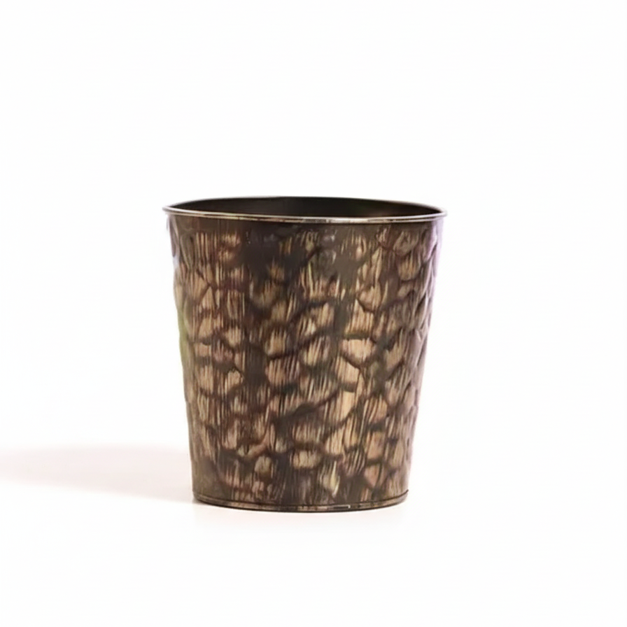 Bronze-colored metal cup with textured surface on a white background