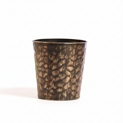 Bronze-colored metal cup with textured surface on a white background