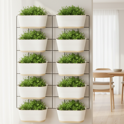 Set of white planters with green plants on a wall-mounted grid in a room with a dining table.