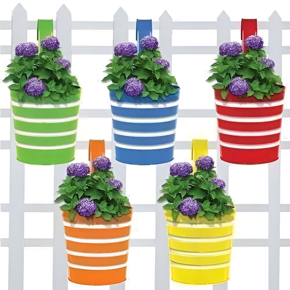 Set of colorful striped hanging planters with flowers against a white picket fence background.