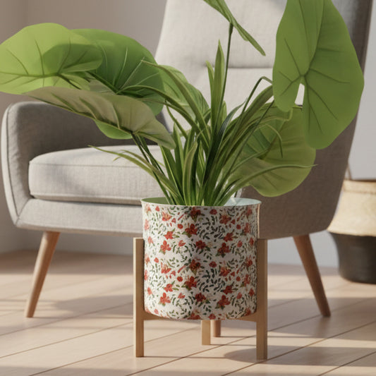 Green potted plant in a decorative pot on a stand against a white background