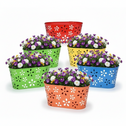 Set of colorful metal planters with flowers on a white background
