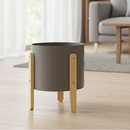 Gray planter with wooden legs on a light wood floor in a living room setting