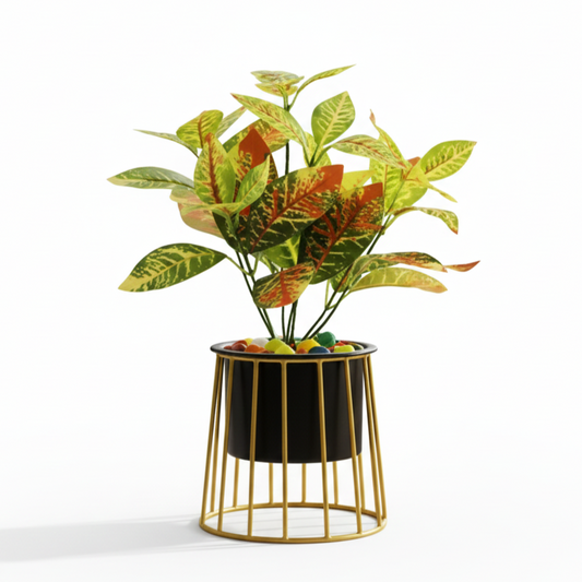 Artificial plant in a decorative black pot with gold wire base on a white background