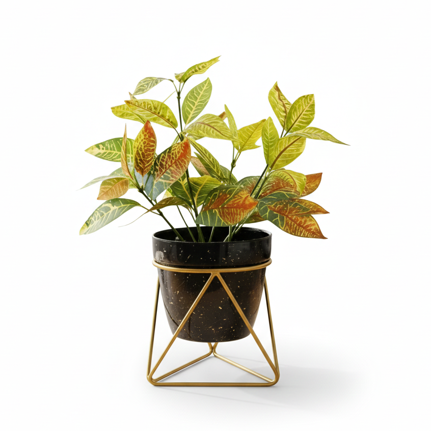 Artificial plant in a black pot with gold geometric stand on a white background