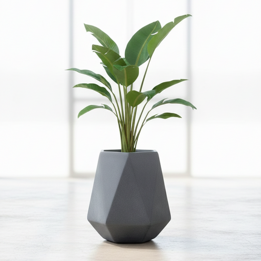 Geometric gray vase with a plant on a light wooden surface