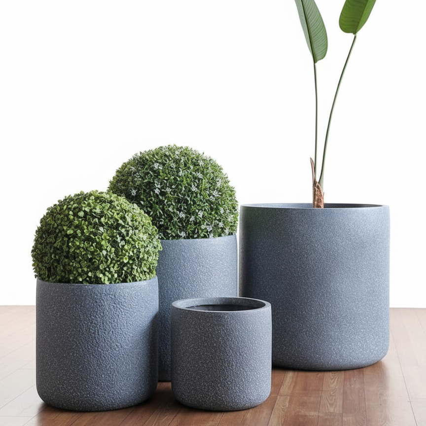 Set of gray textured planters with green plants on a wooden floor.