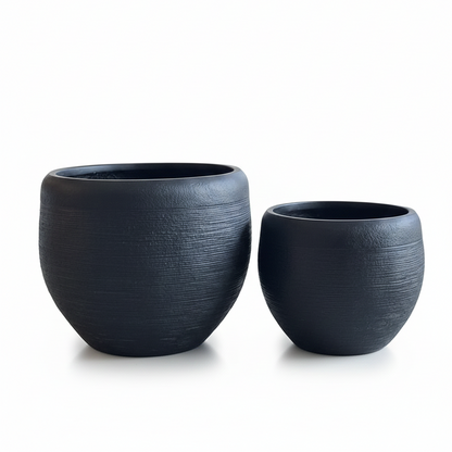 Two dark gray ceramic planters on a white background