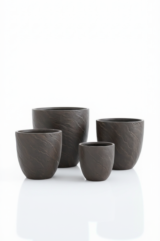 Set of four dark gray ceramic cups on a white background