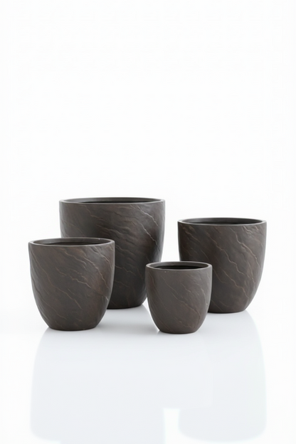 Set of four dark gray ceramic cups on a white background