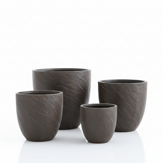 Set of four dark gray ceramic cups on a white background