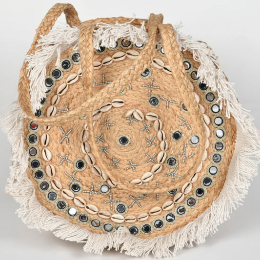 Woven bag with shell embellishments on a light gray background