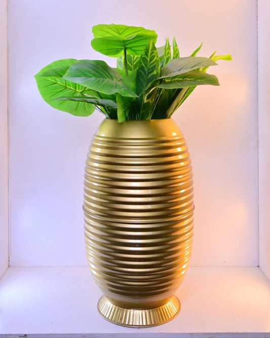 Gold vase with green plant inside on a white background