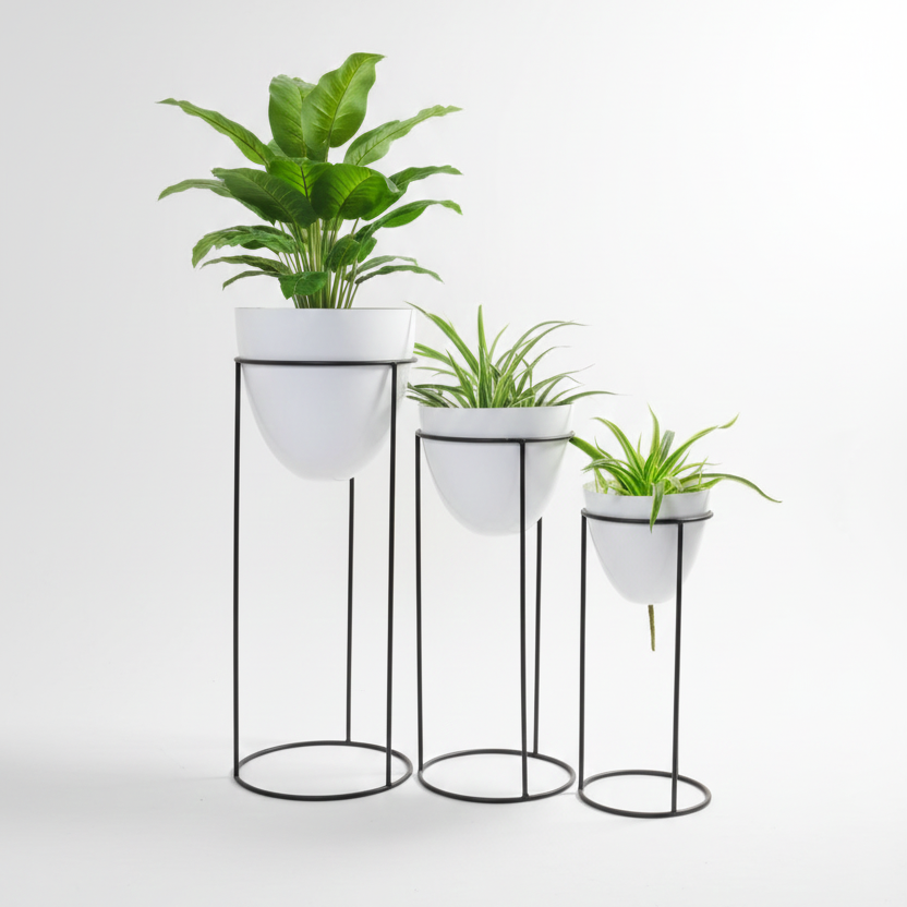 Set of three white planters with plants on black stands against a white background