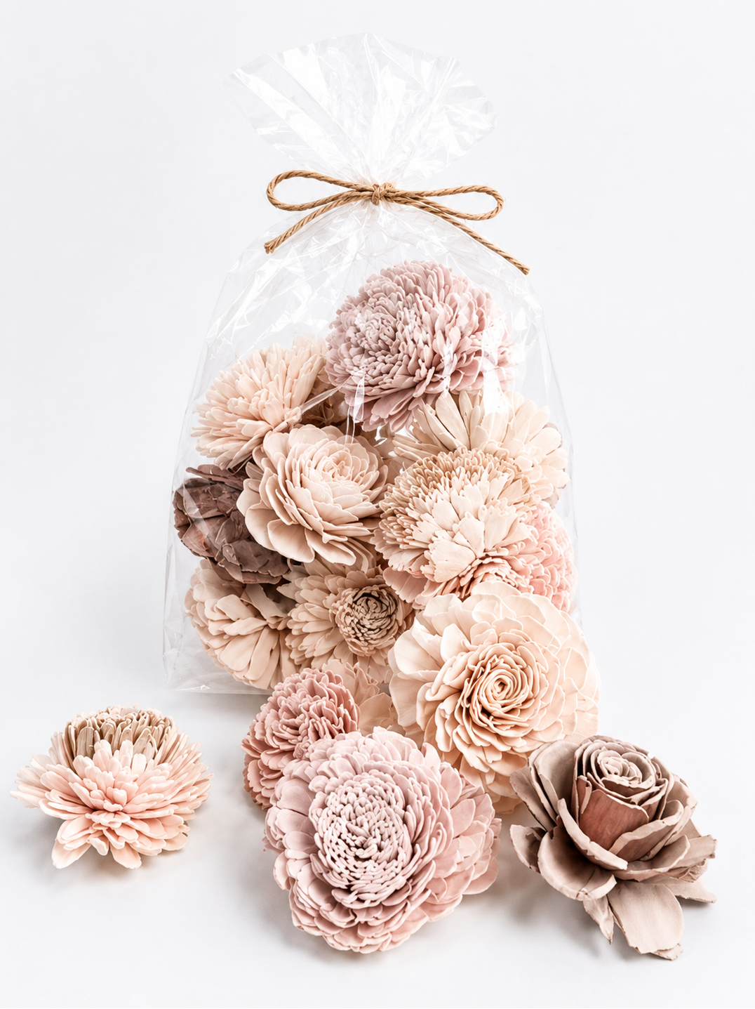 Decorative wall art with pink and beige flowers in a clear bag on a white background