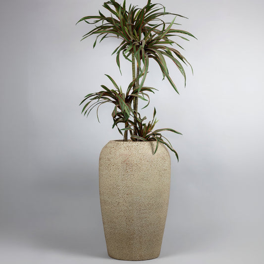 Tall beige textured planter with a green plant on a light gray background