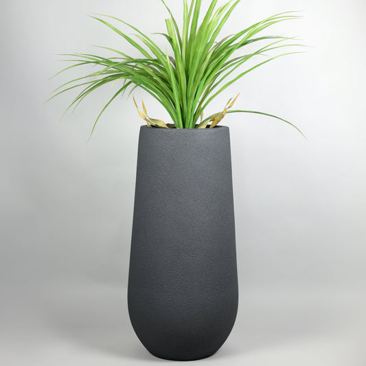 Tall dark gray planter with green plant on a light gray background