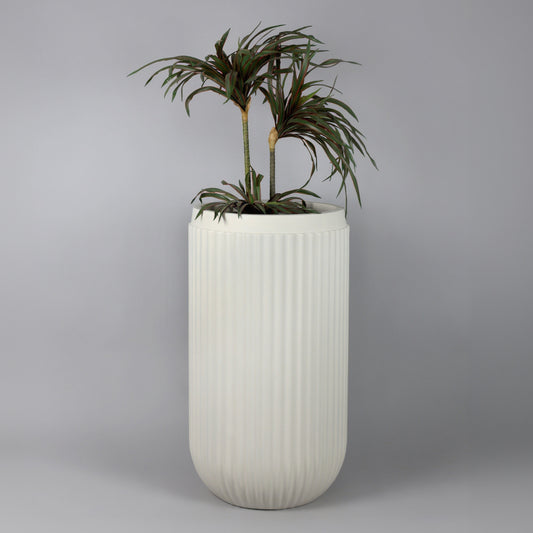 White ribbed planter with a plant on a gray background