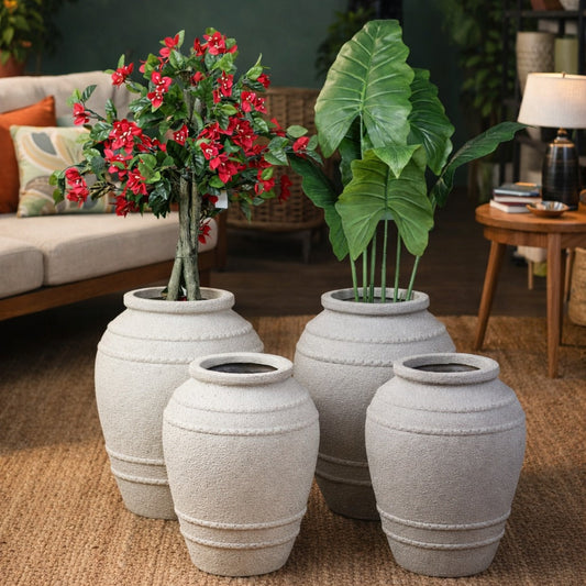 Decorative potted plants in stone-like pots on a living room floor.