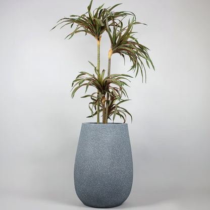 Tall gray textured planter with a green plant on a light gray background
